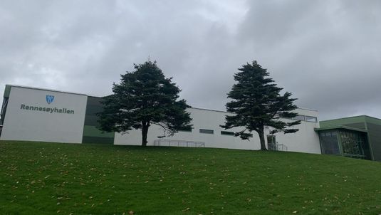 Fasaden til Rennesøyhallen bakom 2 trær